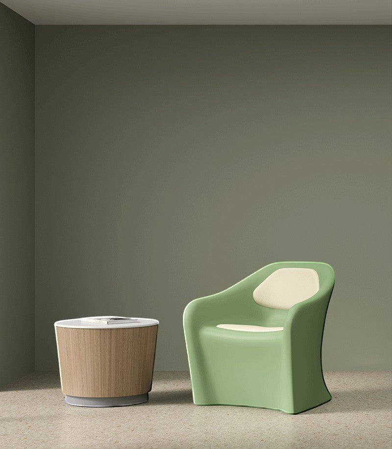 A Flo Lounge Chair with upholstered pads is shown next to a resilia occasional table with solid surface top and plinth base